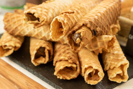 Homemade waffle rolls with condensed milk on buffet.