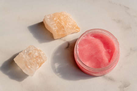 Himalayan salt and pink body or face scrub on marble background. Bath salt. Spa treatment. beauty and relaxation conceptの写真素材