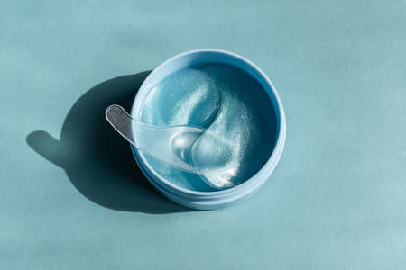 Blue collagen eye mask or patches on a blue background. Skin care and beauty concept. Unbranded mockup.の写真素材