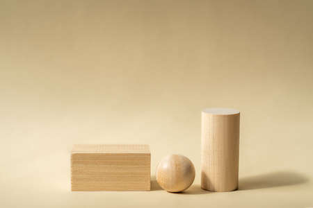 Empty wooden podiums of abstract geometric shapes for product presentations. Copy space for your...