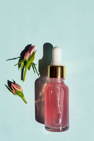 Massage quartz roller for the face of pink natural nephritis with beauty serum or rose essential oil. Skin care facial massage and relaxation. Home massage tools. Anti age and lifting procedures.の写真素材