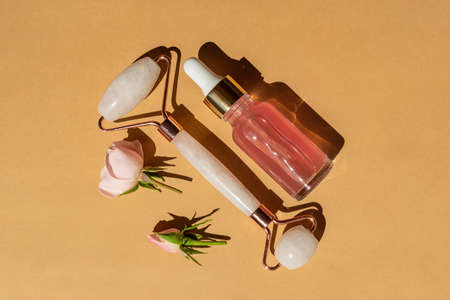 Massage quartz roller for the face of pink natural nephritis with beauty serum or rose essential...