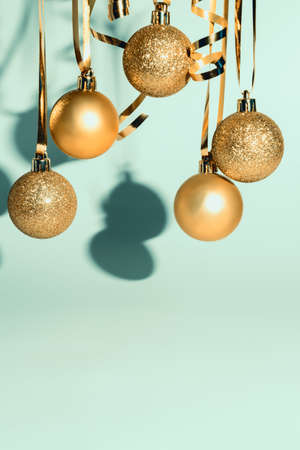 Christmas-tree decoration golden balls and streamers on blue background with copy space for greetings or advertisement.の写真素材