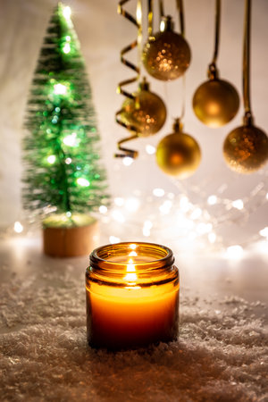 Warm Night Christmas decorations with candles, baubles and fir tree on magic bokeh background. Festive greeting card for winter holidays.の写真素材