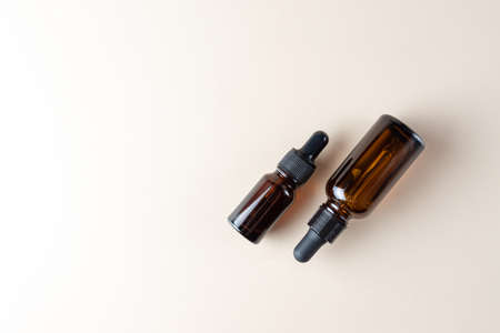 facial essential oil or serum packaging on beige Background. Beauty cosmetic product for skincare concept copy space.の写真素材