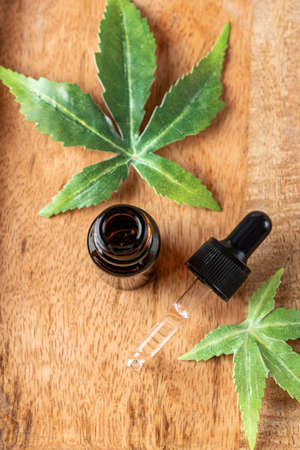 Pharmaceutical CBD oil and cannabis tincture on a wooden background. The concept of medical marijuana and alternative medicine. Organic cosmetics top view.の写真素材