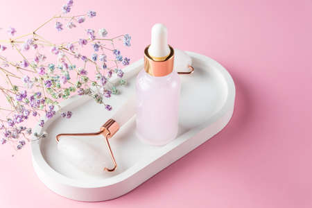 Jade face roller for beauty facial massage therapy and face oil. Anti age, lifting and toning treatment at home. Concept of self and beauty careの写真素材