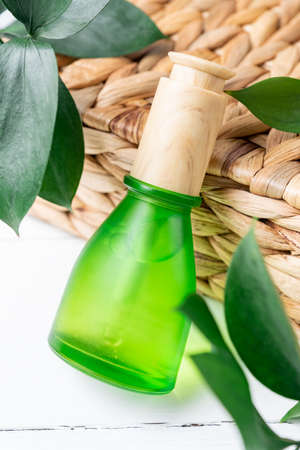 Essential oils with drops pipette on natural background. Grean leaves decoration. Professional bottle for facial and body treatmentの写真素材