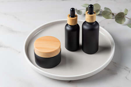 Set of natural cosmetics for mornin and night face care, serum, cream and essential oil on marble...