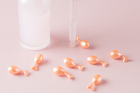 Cosmetic skincare, face capsules with collagen essence. Transparent, glass bottle dropper with pink...