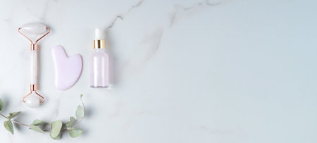 Rose quartz face beauty roller and gua sha scrapper massage. flat lay. beauty blog advertising. Chinese Eastern medicine concept. Banner.の写真素材
