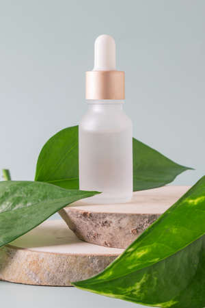 Face serum in a glass package, bottle on a gray background. treatment for skin with oils, vitamins and collagen. Packaging of cosmetic beauty product, copy spaceの写真素材