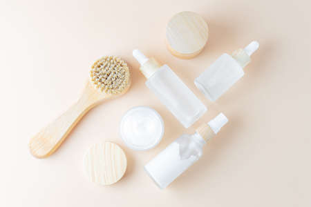 Set of unbranded skin care cosmetics with wooden face brush with natural bristle. Flat lay,...