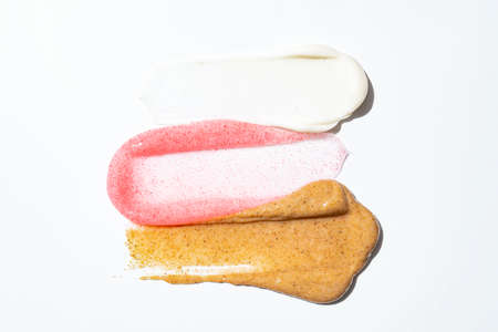 Face scrub creamy texture. White, pink and brown natural cosmetic exfoliation cleanser smear smudge...