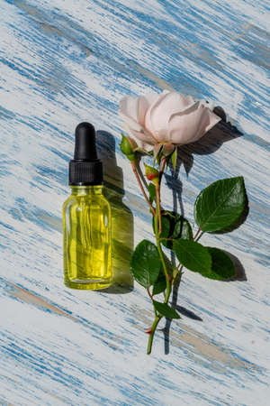 Glass dropper bottle with rose flower. Hyaluronic acid oil, serum with collagen and peptides skin...