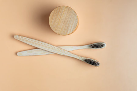 Eco-friendly bamboo toothbrushes and dentifrice on beige background. Natural organic bathroom beauty...