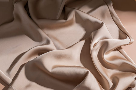 Smooth elegant bronze beige silk or satin luxury cloth texture background. Luxurious background design.の写真素材