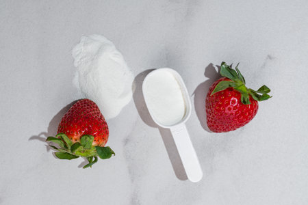 Fresh ripe strawberry with collagen powder or protein in a scoop. Extra protein intake. natural beauty and health supplement. Plant or fish based.の写真素材
