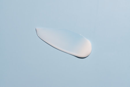 White cosmetic cream texture, skincare lotion swatch on blue background. Face creme, body moisturizer, hair conditioner smear smudge stroke. creamy beauty product closeupの写真素材