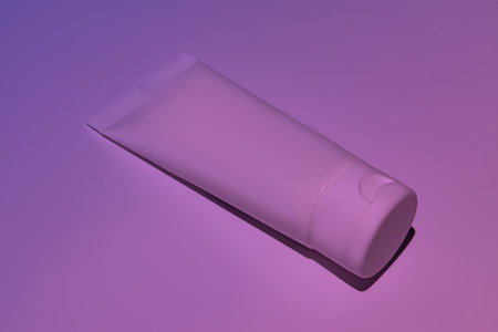 Unbranded white squeeze cosmetic cream bottle tube on neon pink background. Natural oranic spa cosmetics concept. mockup templateの写真素材