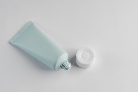 Top view of green squezze tube with open cap on white background. cosmetics mockup.の写真素材