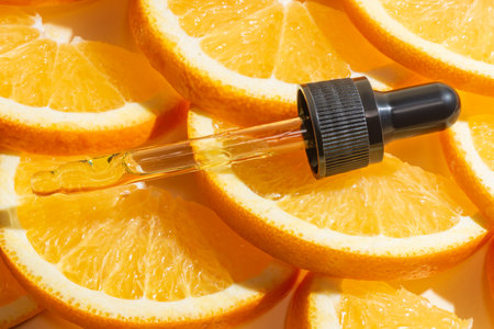 Vitamin c serum extract in dropper pipette with sliced oranges. Natural skin care cosmeticsの写真素材