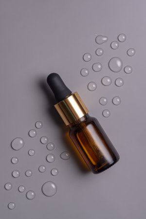 Trendy background with natural cosmetic skincare bottle. Product presentation. Beauty and body care product concept. Bottle with face oil or beauty serum with vitamin C or retinol.の写真素材