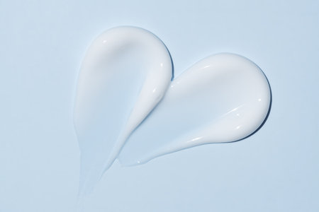 Scrub strokes isolated on blue background. White exfoliation cream smear smudge sample. Peeling scrubbing face or body skincare product swatch. showcase of the productの写真素材