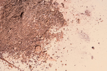 Crushed face powder bronzer, powder isolated on beige background, space for text, cosmetics swatch...