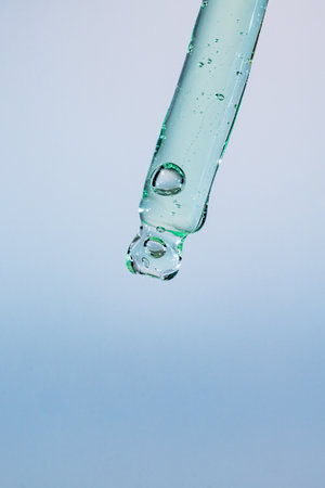 Cosmetic pipette with vitamin collagen serum or essential oil on light background. Skin care...