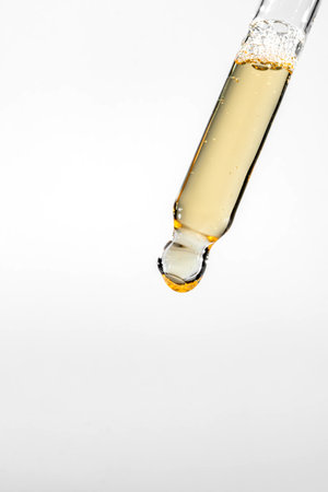 Cosmetic pipette with dripping liquid and drops on white background, serum, serum, gel, vitamin, water, oil.の写真素材