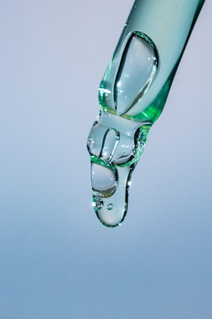 A drop of cosmetic aloe gel falls from the pipette
