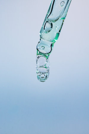 A drop of cosmetic aloe gel falls from the pipetteの写真素材