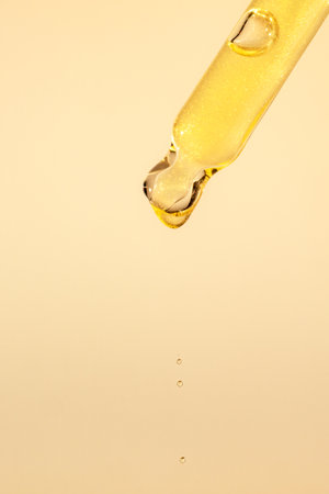 Pipette with serum, gel, oil or other cosmetic product with falling drop. Macro closeupの写真素材