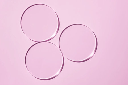 Empty Petri dishes on a pink background. Bright sunlight. Deep shadows. Contrast. Laboratory. cosmetic lab item, round transparent glass dishの写真素材