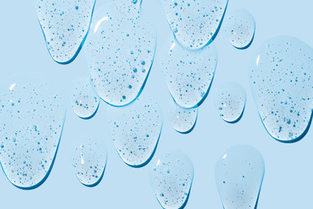 Pure transparent cosmetic gel smears on blue background, skin care glycerin texture. top view. patternの写真素材