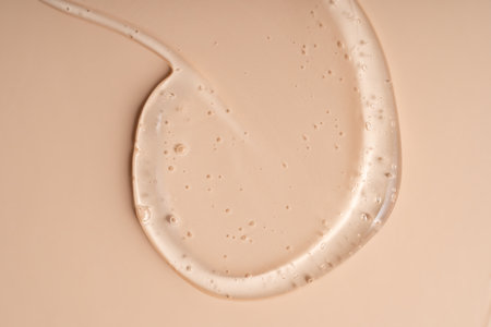 Liquid gel smear isolated on beige background. Beauty cosmetic smudge such as pure transparent aloe...