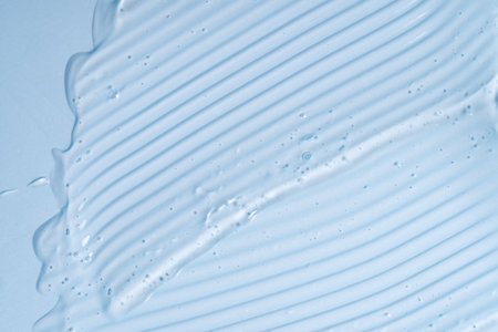 Liquid gel abstract cosmetic in blue background. Smear of transparent moisturizing productの写真素材