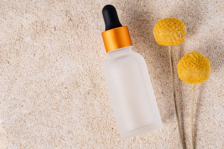 Beauty collagen face oil in a glass dropper bottle. Trendy shoot of cosmetics packaging. Essential oil with natural ingredients on sandstone backgroundの写真素材