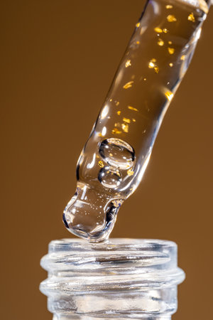 Serum pipette dripping to the bottle on dark brown background.