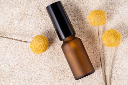Amber glass bottle with open cap and blank label, cream on a natural stone stand on beige background. Natural Organic Spa Cosmetic mock up. minimal aesthetic cosmetic skin care product.の写真素材