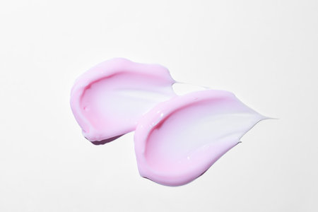 Texture of pink cream on white background. Smear of moisturizer close up. Lotion swatch. Beauty skin...