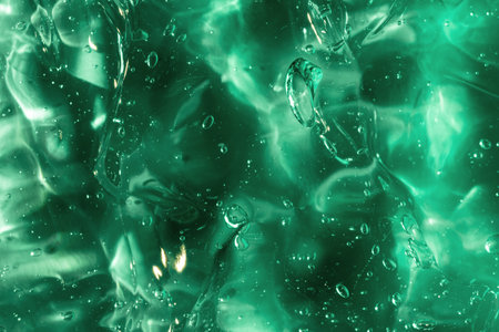Liquid gel abstract cosmetic in green background. Smear of transparent moisturizing product of aloeの写真素材