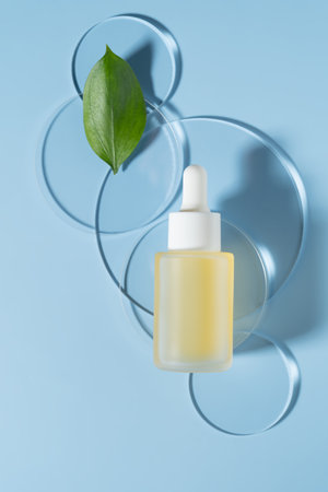 Organic cosmetic product, Face serum with natural ingredient and laboratory glassware on blue background, top viewの写真素材
