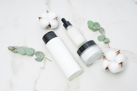 Set of amber glass cosmetic bottles on marble table. dropper bottle, toner and cream jar package. Skincare beauty products packaging design for daily routineの写真素材