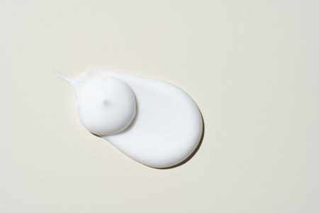 White cosmetic cream texture, skincare lotion swatch on light beige background. Face creme, body...