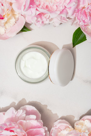Top view of jar with face cream and pink peony flowers. Natural organic cosmetics conceptの写真素材