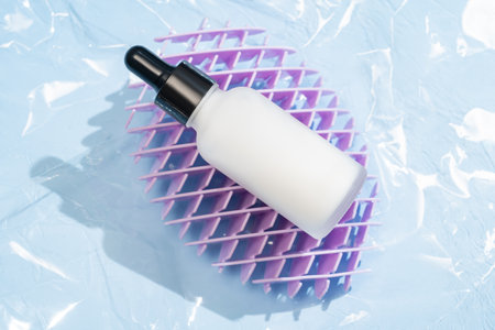 White dropper bottle with beauty serum on blue backgroundの写真素材