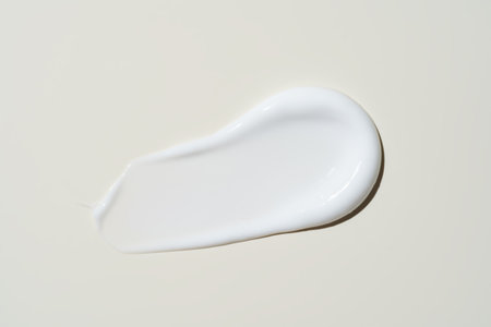 Close-up of a finger swiping rich face cream across a beige backdrop, capturing its velvety texture for skincare brandingの写真素材