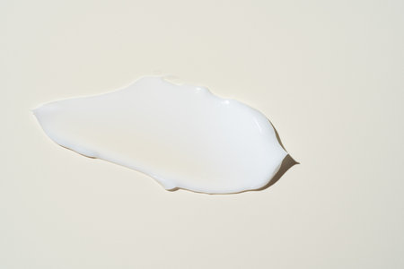 Luxurious cream dabbed and blended on neutral surface, highlighting smooth application for moisturizer campaigns.の写真素材